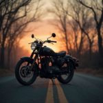 Vintage motorcycle parked on a deserted road at dusk with an orange-glow sky