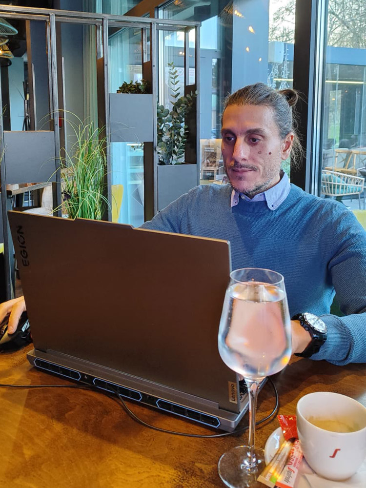 Nenad Dukić, founder of DEUSPIXEL, working on printable wall art designs on his laptop